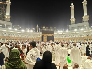 Night view of pilgrims gathered around the Kaaba in Mecca, Saudi Arabia during Hajj.