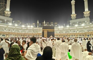 Night view of pilgrims gathered around the Kaaba in Mecca, Saudi Arabia during Hajj.
