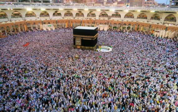 Aerial view of a large crowd of pilgrims gathered around the Kaaba in Mecca for religious rituals.